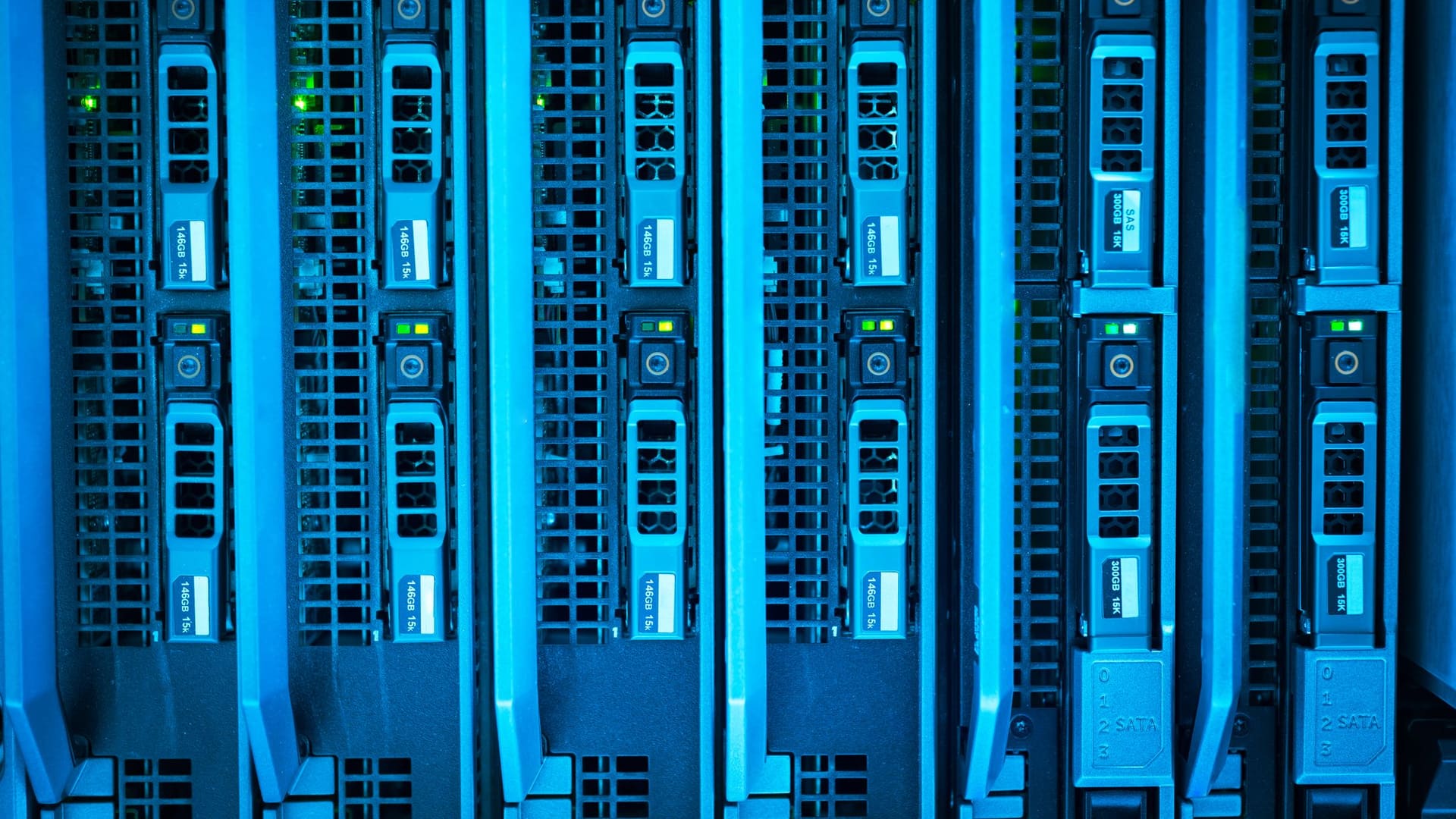 Rows of illuminated server racks and network cabling in a data centre.